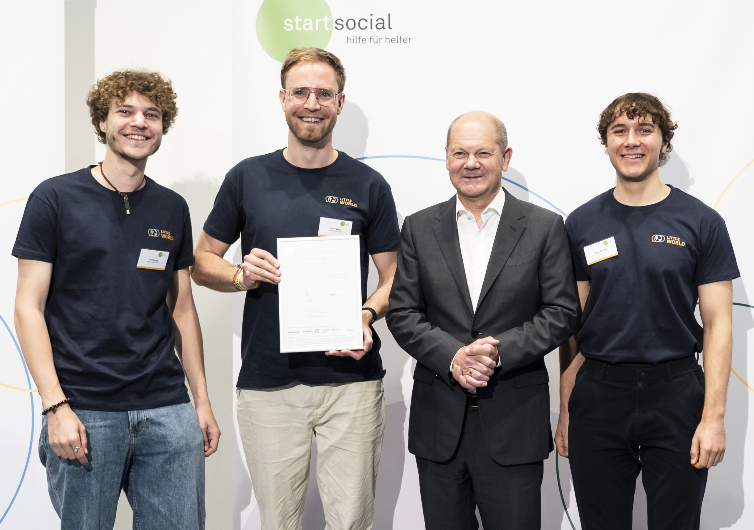 Gruppenfoto von Tim, Oliver mit Urkunde, Sean und Olaf Scholz