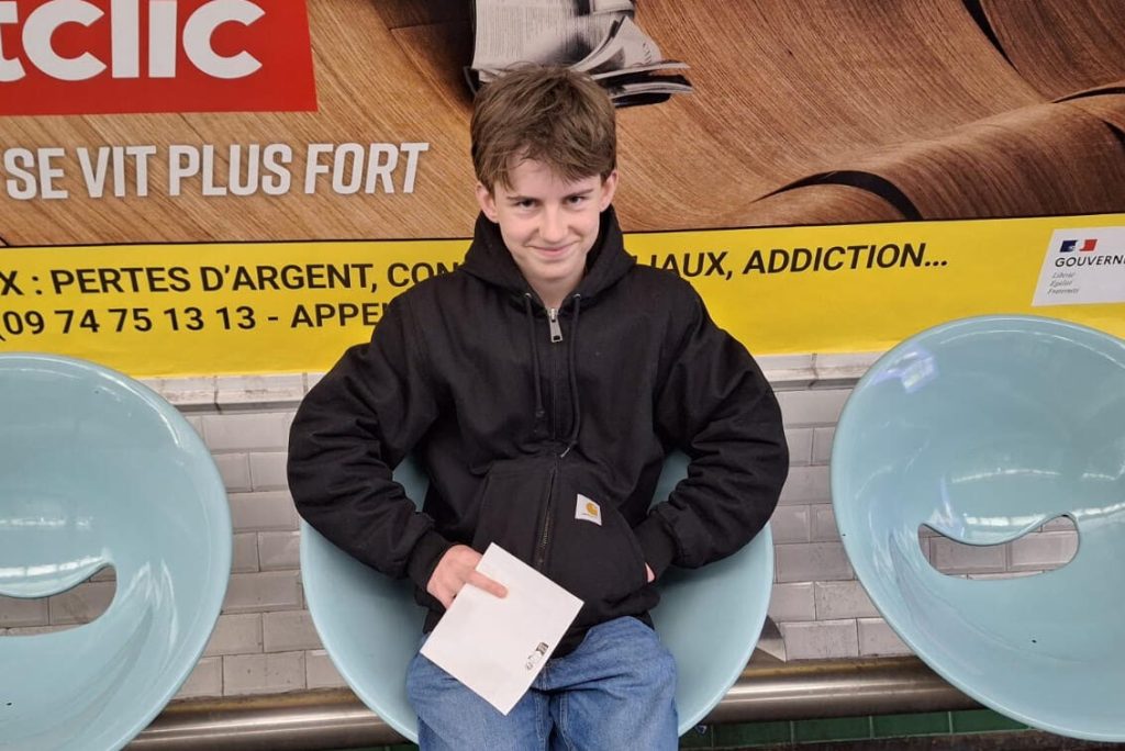 Lasse, ein junger Mann mit Hoodie sitzt in einer Metrostation