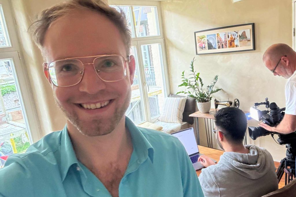 Oliver dokumentiert den Lokalzeit-Dreh mit Kunal im Hintergrund mit einem Selfie