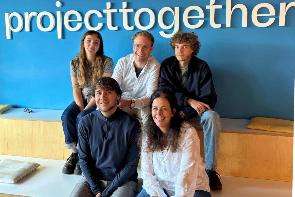 Alice, Oliver, Tim, Sean und Melina unter dem projecttogether-Schriftzug im Co-Working-Space