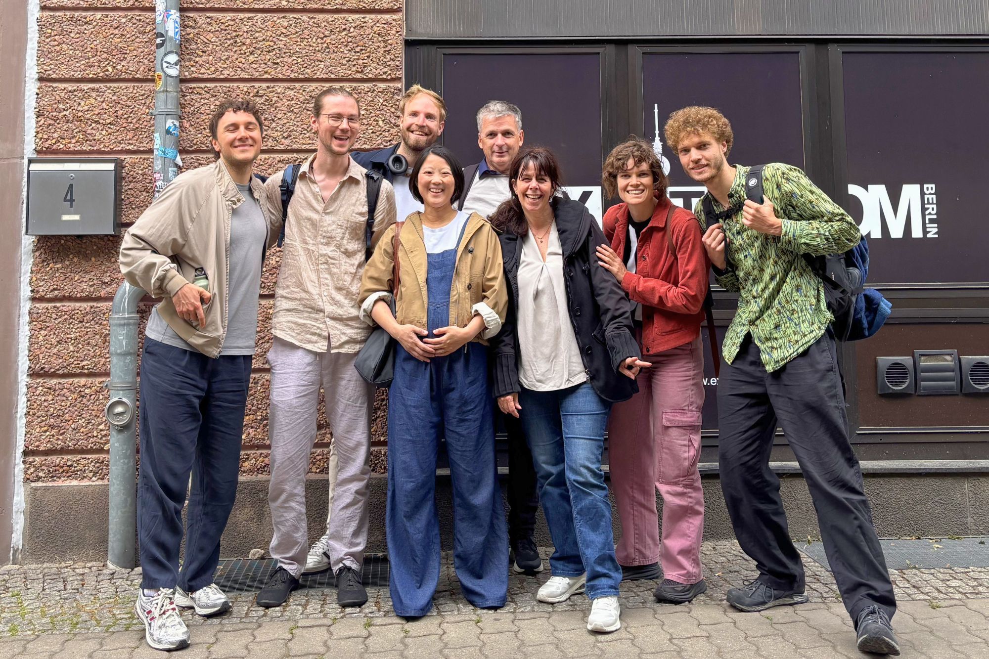 Team von Little World verabschiedet sich lächelnd nach zwei Tagen in Berlin und posiert für ein Gruppenfoto.